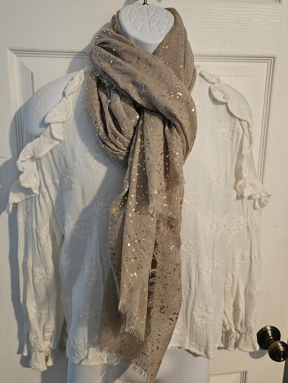 Woman's lightweight cream colored scarf with gold flecks